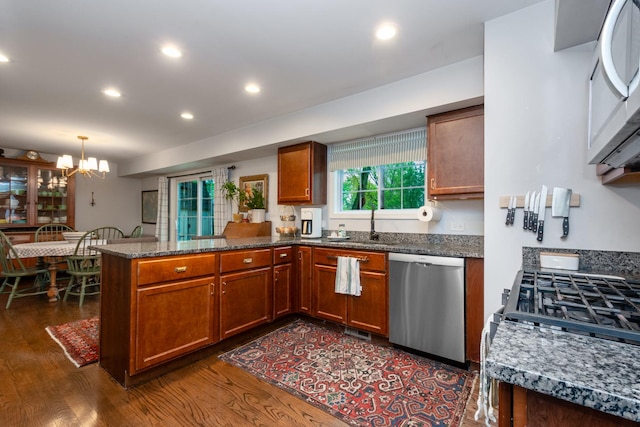 18450 W Streamwood Ct, Gurnee, IL 60031 - kitchen with stainless steel appliances, a peninsula, dark wood-style floors, brown cabinetry, and a chandelier