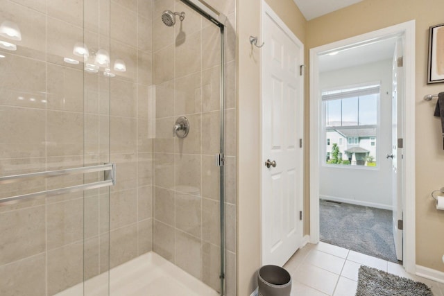 full bathroom with a shower stall, tile patterned floors, and baseboards