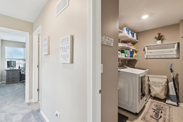 laundry area featuring baseboards, washing machine and dryer, and light colored carpet