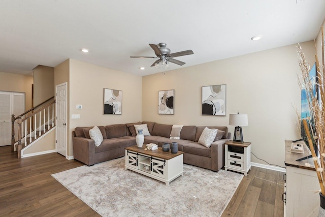 living area with dark wood-type flooring, ceiling fan, stairway, baseboards, and recessed lighting