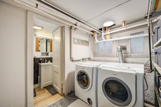 laundry room featuring washing machine and clothes dryer and light wood-style flooring