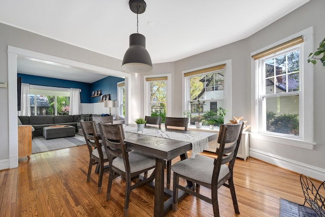 dining area featuring light wood-type flooring and baseboards