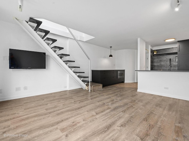 1221 N Dearborn St Unit 1401S, Chicago, IL 60610 - unfurnished living room featuring stairway, wood finished floors, a sink, and baseboards