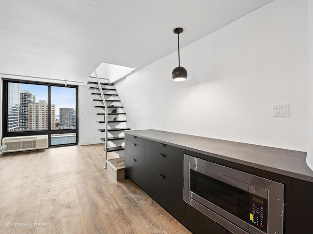 1221 N Dearborn St Unit 1401S, Chicago, IL 60610 - bar featuring stainless steel microwave, light wood-type flooring, decorative light fixtures, an AC wall unit, and floor to ceiling windows