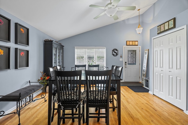 dining space with lofted ceiling, a ceiling fan, and light wood-type flooring