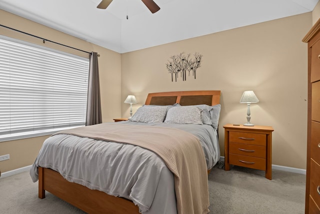 bedroom featuring light colored carpet, baseboards, and ceiling fan