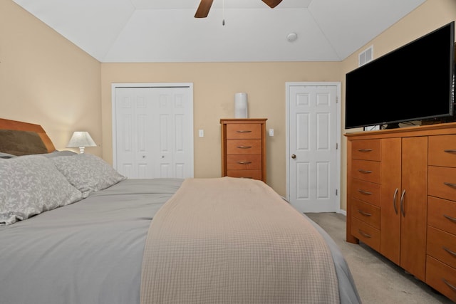 bedroom featuring vaulted ceiling, light colored carpet, a closet, and a ceiling fan