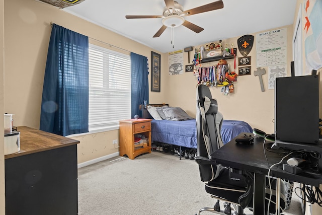carpeted office space with a ceiling fan and baseboards