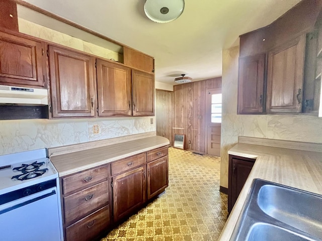 2445 E Wood St, Decatur, IL 62521 - kitchen with gas range gas stove, under cabinet range hood, light countertops, a sink, and backsplash