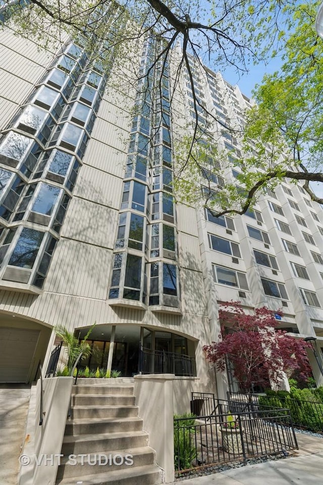 view of apartment building / complex with stairs and fence