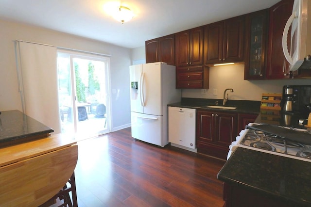 2210 Sandburg Dr, Aurora, IL 60506 - kitchen featuring white appliances, a sink, dark countertops, dark wood-style floors, and glass insert cabinets