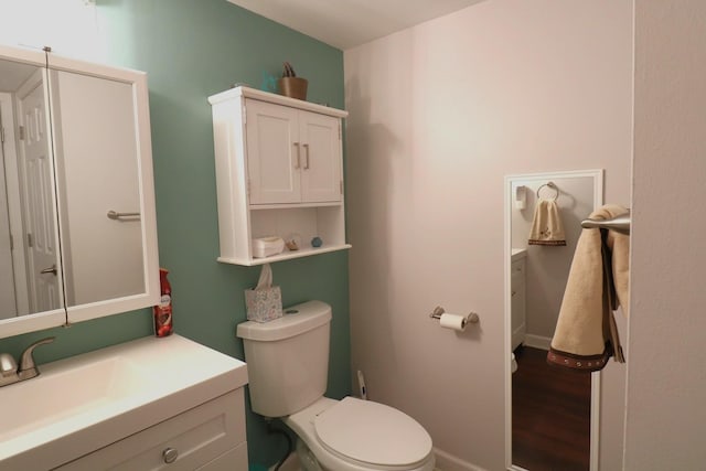 2210 Sandburg Dr, Aurora, IL 60506 - half bathroom featuring vanity, toilet, wood finished floors, and baseboards