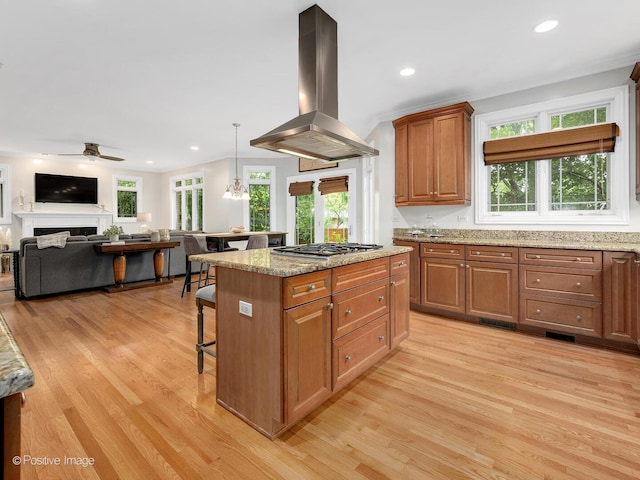 220 Kings Ct, La Grange Park, IL 60526 - kitchen featuring island range hood, stainless steel gas stovetop, light wood-style floors, a kitchen breakfast bar, and recessed lighting