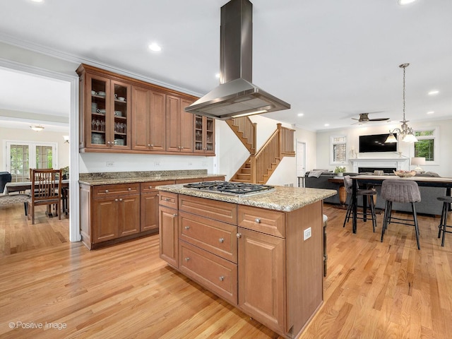 220 Kings Ct, La Grange Park, IL 60526 - kitchen with island range hood, stainless steel gas cooktop, open floor plan, light wood-style floors, and crown molding