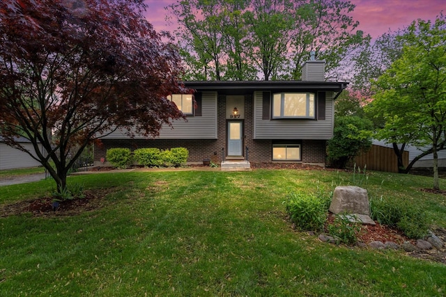 917 N Coolidge Ave, Palatine, IL 60067 - raised ranch featuring brick siding, a chimney, a front lawn, and entry steps