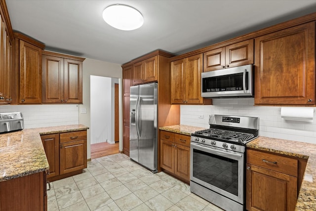 917 N Coolidge Ave, Palatine, IL 60067 - kitchen with stainless steel appliances, tasteful backsplash, brown cabinets, and light stone countertops