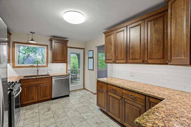 917 N Coolidge Ave, Palatine, IL 60067 - kitchen featuring stainless steel appliances, a sink, tasteful backsplash, hanging light fixtures, and light stone countertops