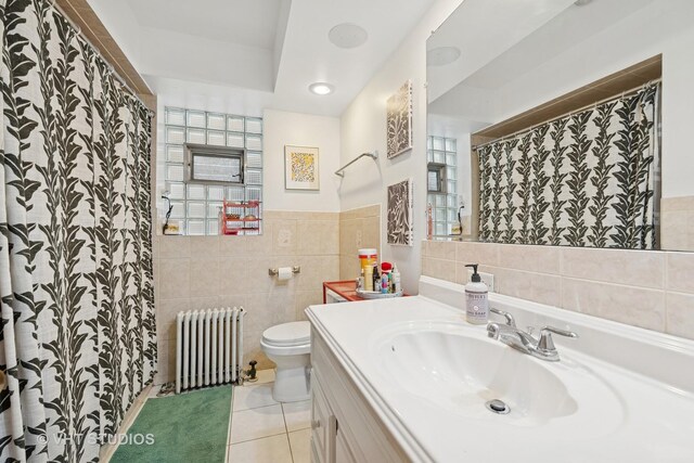 4842 N California Ave, Chicago, IL 60625 - full bathroom featuring radiator, tile walls, tile patterned flooring, toilet, and vanity