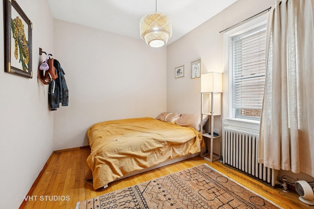 4842 N California Ave, Chicago, IL 60625 - bedroom with radiator heating unit, wood finished floors, and baseboards
