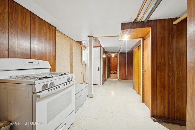 4842 N California Ave, Chicago, IL 60625 - kitchen featuring white gas range, wooden walls, and light floors