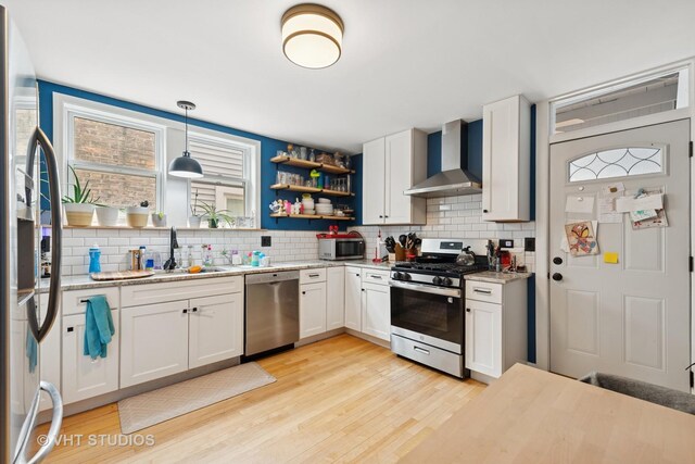 4842 N California Ave, Chicago, IL 60625 - kitchen with stainless steel appliances, wall chimney range hood, a sink, and decorative backsplash