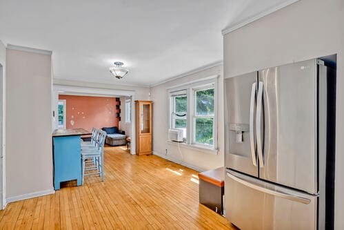 1144 N Austin Blvd, Oak Park, IL 60302 - kitchen with stainless steel fridge with ice dispenser, light wood-style floors, baseboards, cooling unit, and ornamental molding