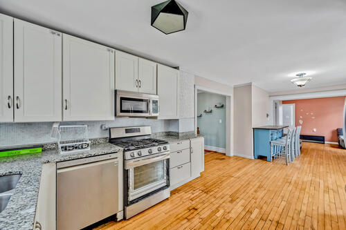 1144 N Austin Blvd, Oak Park, IL 60302 - kitchen featuring stainless steel appliances, tasteful backsplash, white cabinets, and light wood-style floors