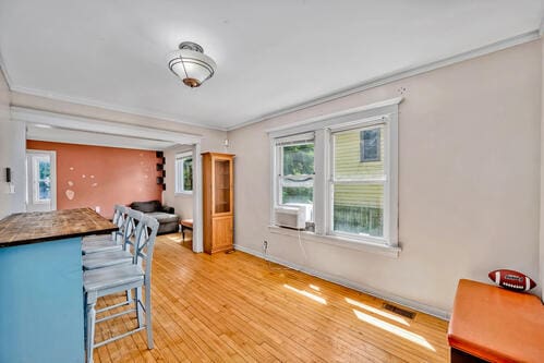 1144 N Austin Blvd, Oak Park, IL 60302 - kitchen with crown molding, plenty of natural light, a breakfast bar, light wood-style flooring, and baseboards