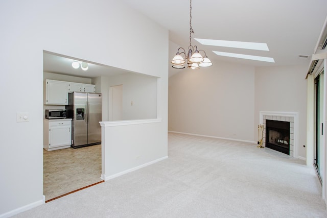 1402 Orange Ct Unit D, Mount Prospect, IL 60056 - unfurnished living room with a skylight, light colored carpet, a chandelier, vaulted ceiling, and a tiled fireplace