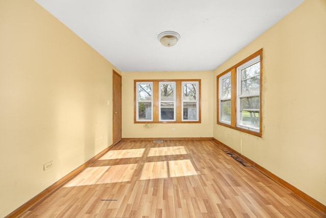 spare room with light wood-type flooring and baseboards