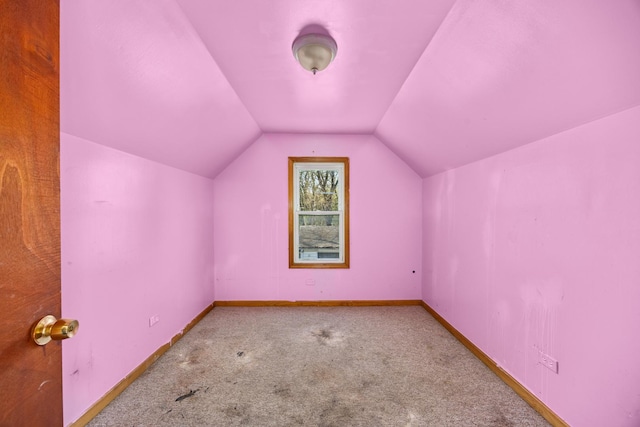 additional living space featuring carpet, lofted ceiling, and baseboards