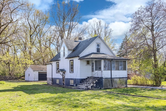 bungalow-style home featuring a shingled roof, an outdoor structure, a shed, and a front lawn