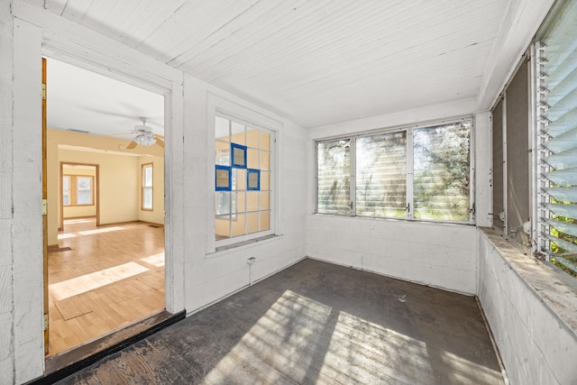 unfurnished sunroom featuring plenty of natural light and a ceiling fan