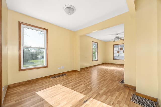 unfurnished room featuring light wood finished floors, baseboards, and ceiling fan
