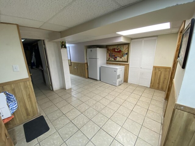 3846 Brummel St, Skokie, IL 60076 - finished below grade area featuring freestanding refrigerator, wainscoting, a paneled ceiling, wood walls, and fridge