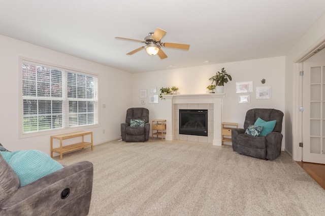 living room featuring ceiling fan, a fireplace, and carpet flooring