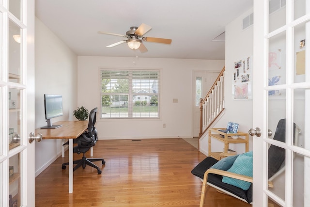 office area featuring french doors, light wood-style floors, a ceiling fan, and baseboards