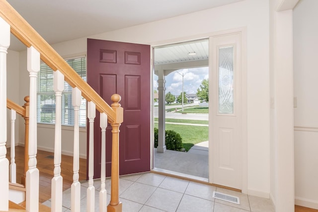 foyer with stairs, light tile patterned floors, and baseboards