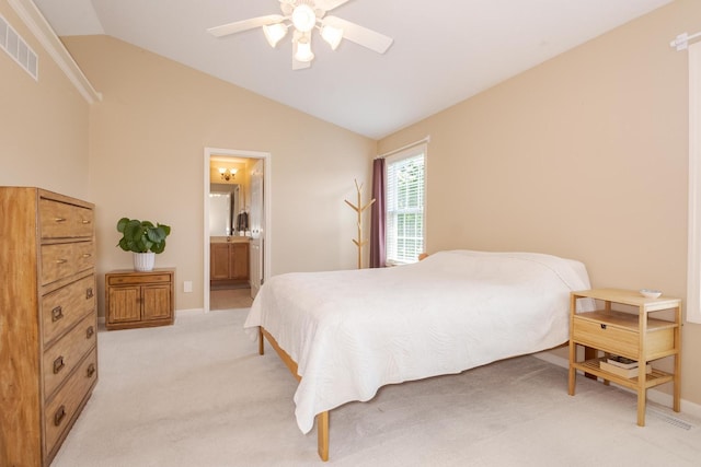 bedroom with vaulted ceiling, light colored carpet, baseboards, ensuite bathroom, and a ceiling fan