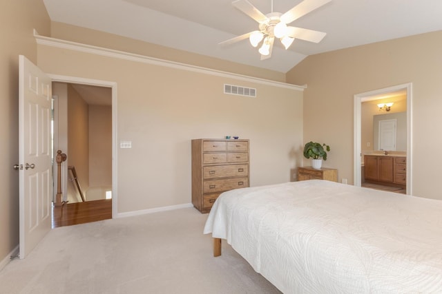 bedroom featuring light carpet, lofted ceiling, a ceiling fan, baseboards, and connected bathroom