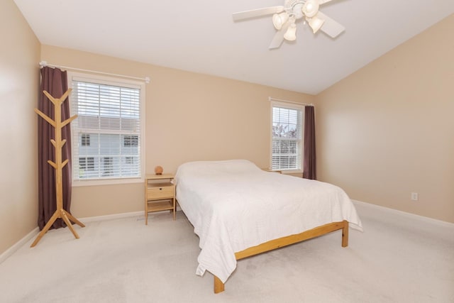 bedroom featuring light carpet, a ceiling fan, baseboards, and lofted ceiling
