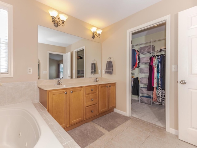 full bath with a tub with jets, double vanity, tile patterned floors, a spacious closet, and plenty of natural light