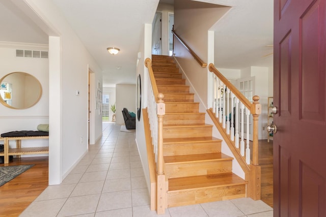 foyer entrance with stairs and light tile patterned flooring
