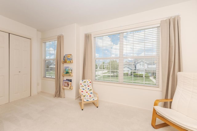 living area featuring plenty of natural light, carpet floors, and baseboards