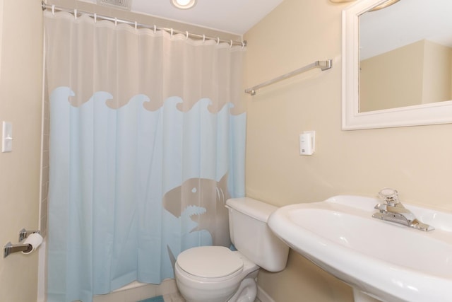 full bath featuring a sink, toilet, and a shower with shower curtain
