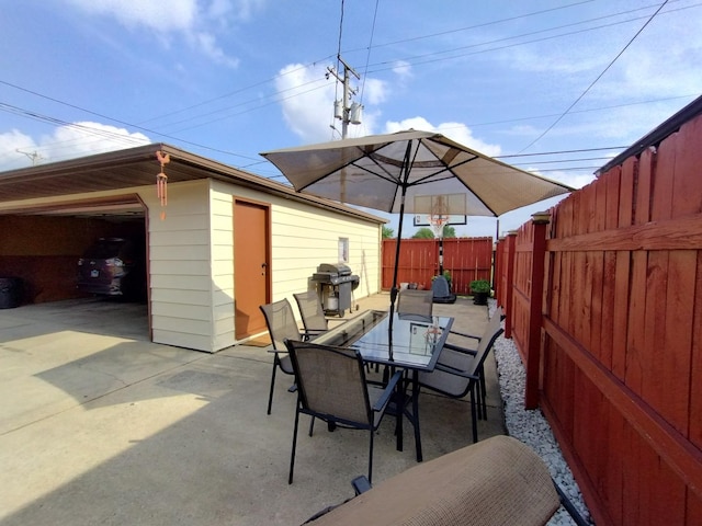 1173 Lucas St, Calumet City, IL 60409 - view of patio featuring outdoor dining area, a fenced backyard, an outbuilding, and a garage