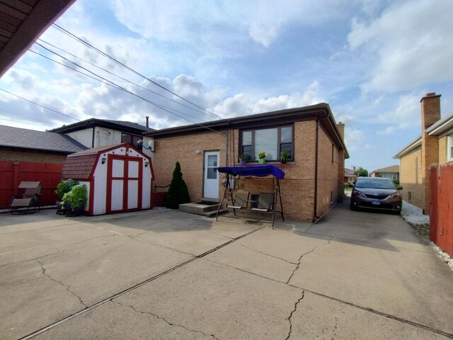1173 Lucas St, Calumet City, IL 60409 - view of front of home featuring a storage shed, fence, brick siding, and an outdoor structure