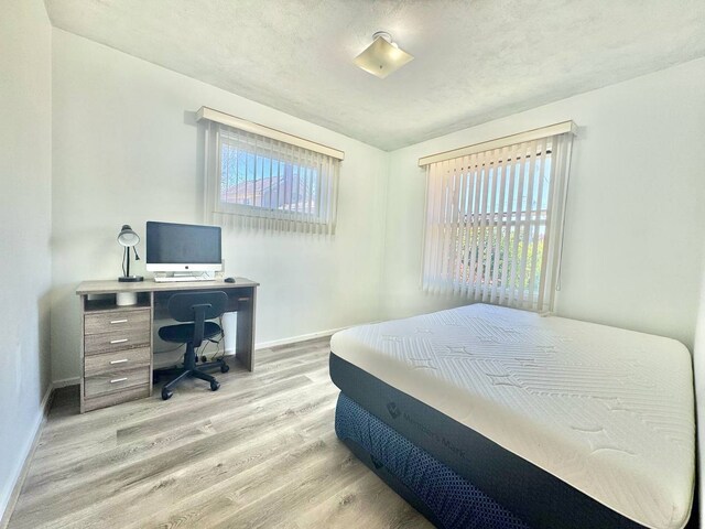 8344 N Milwaukee Ave, Niles, IL 60714 - bedroom featuring wood finished floors, baseboards, and a desk
