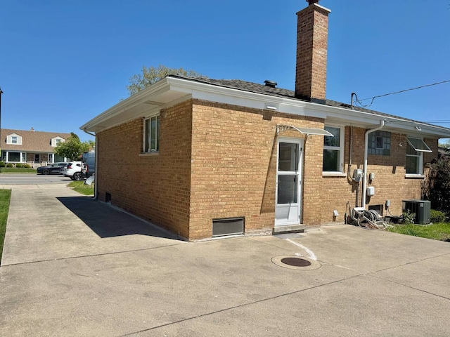 8344 N Milwaukee Ave, Niles, IL 60714 - back of property with a chimney, cooling unit, brick siding, and a patio area