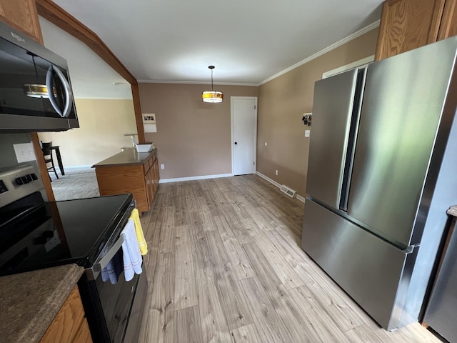 7427 Mccurry Rd, Roscoe, IL 61073 - kitchen with stainless steel appliances, brown cabinetry, dark countertops, light wood-type flooring, and ornamental molding